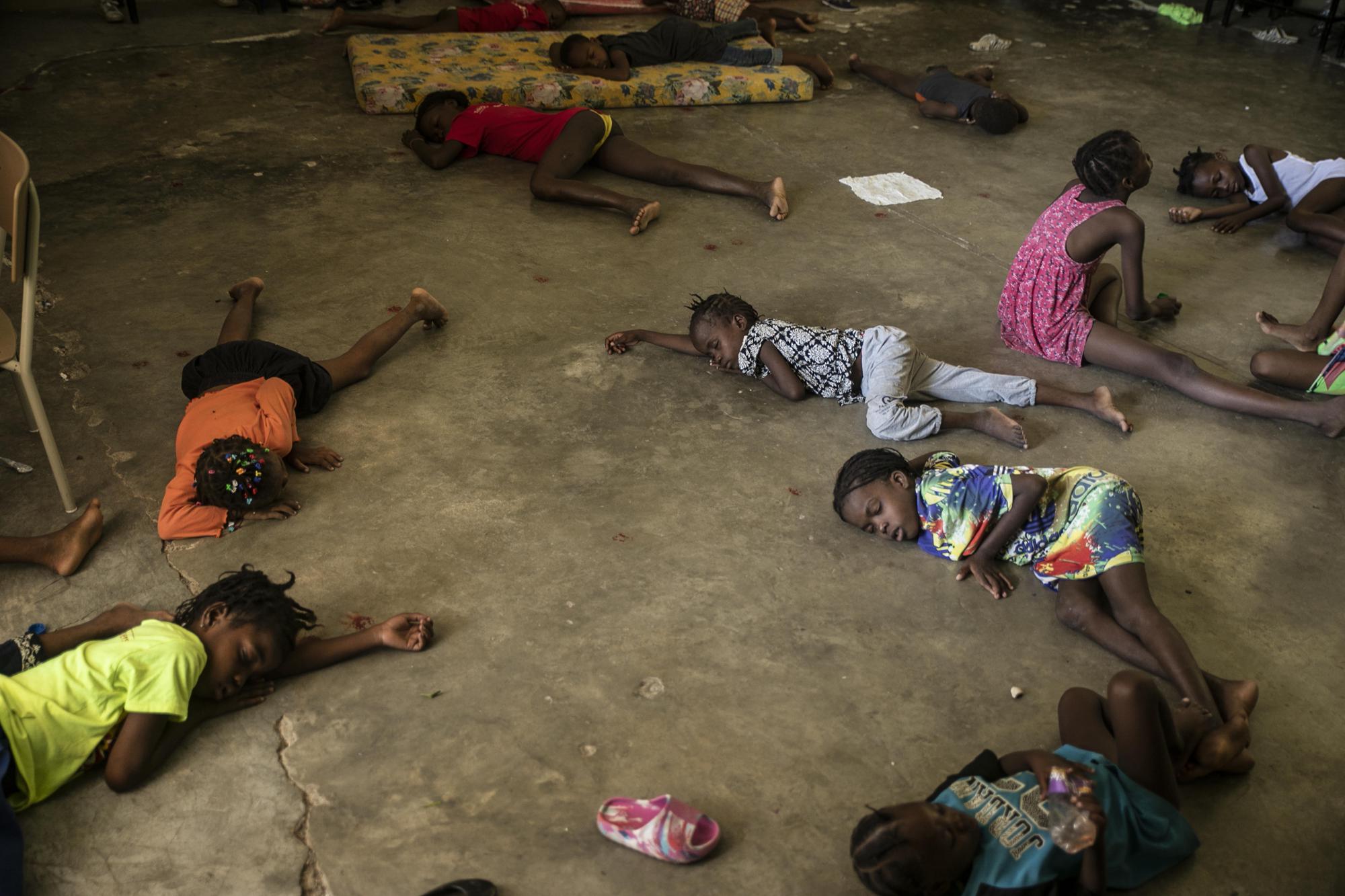 10. Children sleep on the floor of a school turned into a shelter after they were forced to leave their homes in Cite Soleil due to clashes between armed gangs, in Port-au-Prince, Haiti, on July 23, 2022.